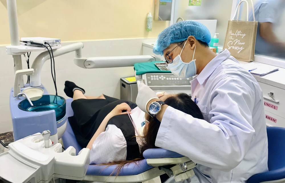 Bác sĩ Bệnh viện Răng Hàm Mặt TP.HCM khám răng cho thai phụ tại Bệnh viện Hùng Vương. Ảnh: THẢO PHƯƠNG