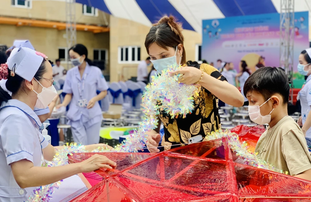 Chị Lê Thị Út Tiên cùng con trai chăm chú làm lồng đèn. Ảnh: THẢO PHƯƠNG trung-thu4-8276-8800.jpg