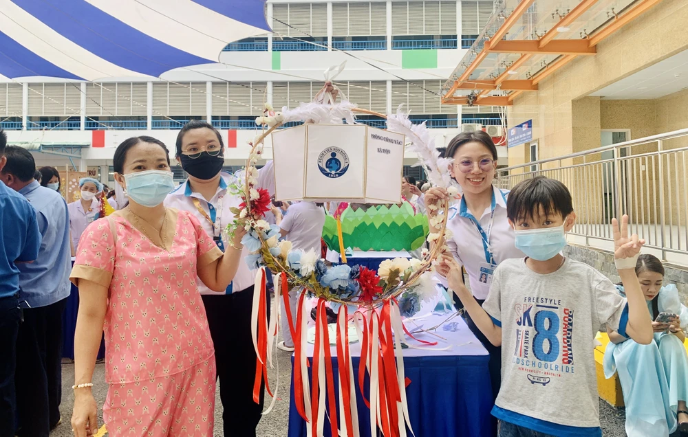 Thân nhân, bệnh nhi và nhân viên y tế cùng nhau hoàn thành chiếc lồng đèn trung thu. Ảnh: THẢO PHƯƠNG trung-thu8.jpg