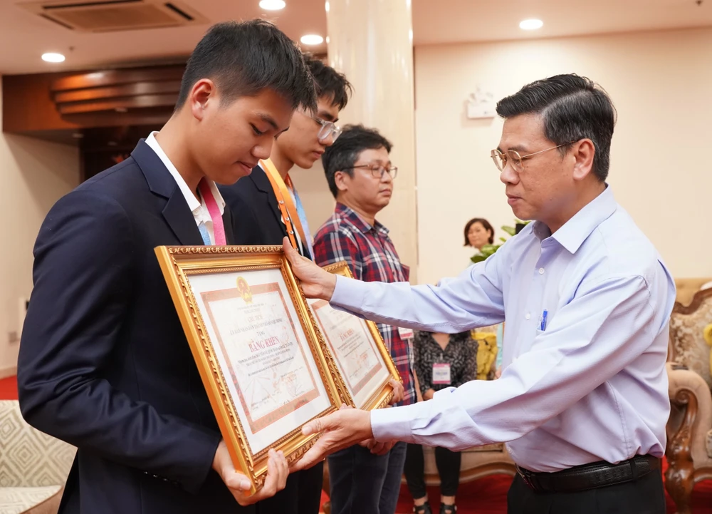 Phó Chủ tịch UBND TP.HCM Nguyễn Văn Dũng trao bằng khen cho 2 học sinh đạt giải nhì cuộc thi khoa học kỹ thuật quốc tế. Ảnh: HOÀNG QUÂN khoa học kỹ thuật - 1