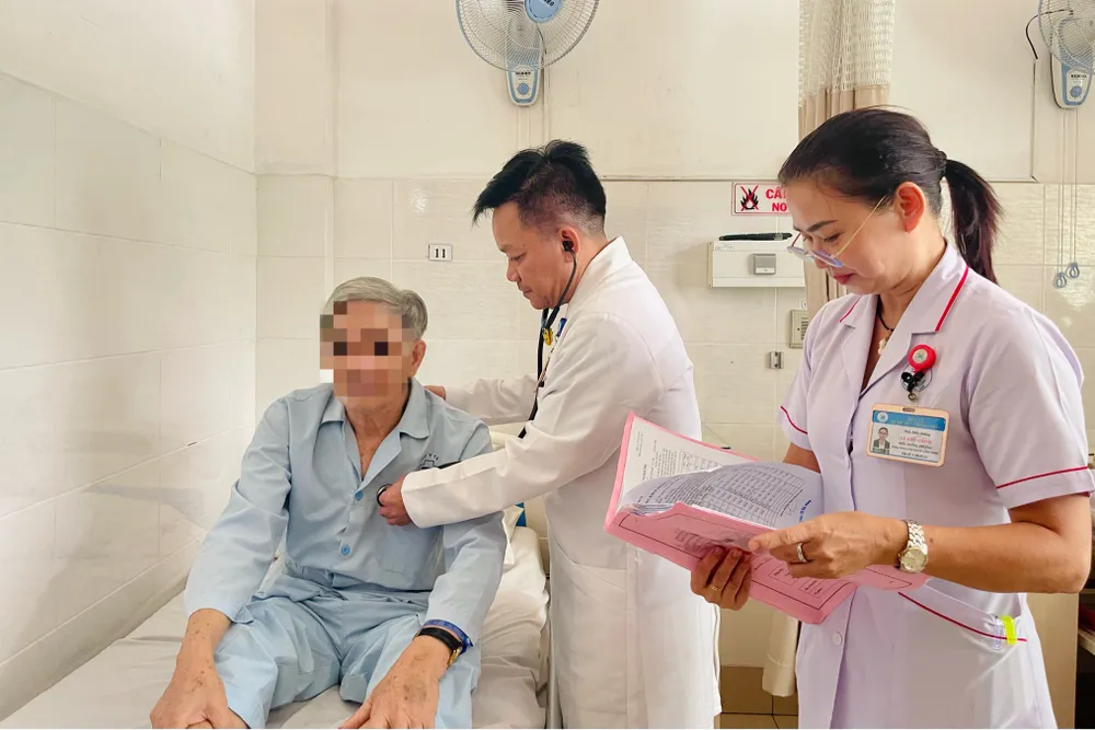 TS.BS Nguyễn Duy Tân, Trưởng khoa Ngoại tim mạch - Lồng ngực, thăm khám cho bệnh nhân 70 tuổi bị tắc động mạch chủ. Ảnh: THẢO PHƯƠNG tắc động mạch chủ - 1
