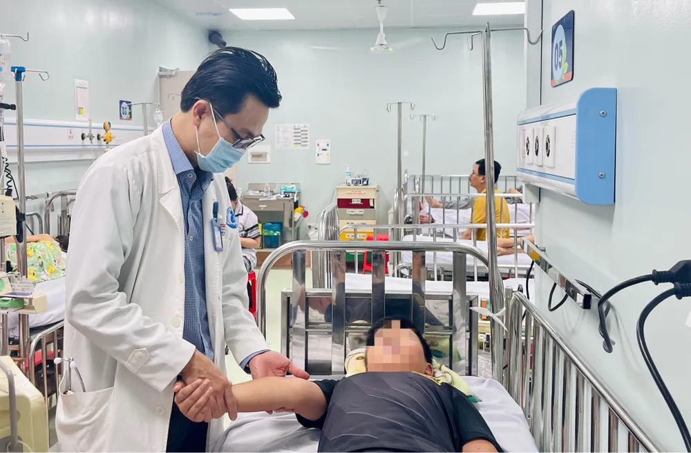 TS.BS Nguyễn Minh Tuấn, Trưởng khoa Sốt xuất huyết Bệnh viện Nhi đồng 1, thăm khám cho bệnh nhi sốt xuất huyết. Ảnh: THẢO PHƯƠNG sot-xuat-huyet8.jpg