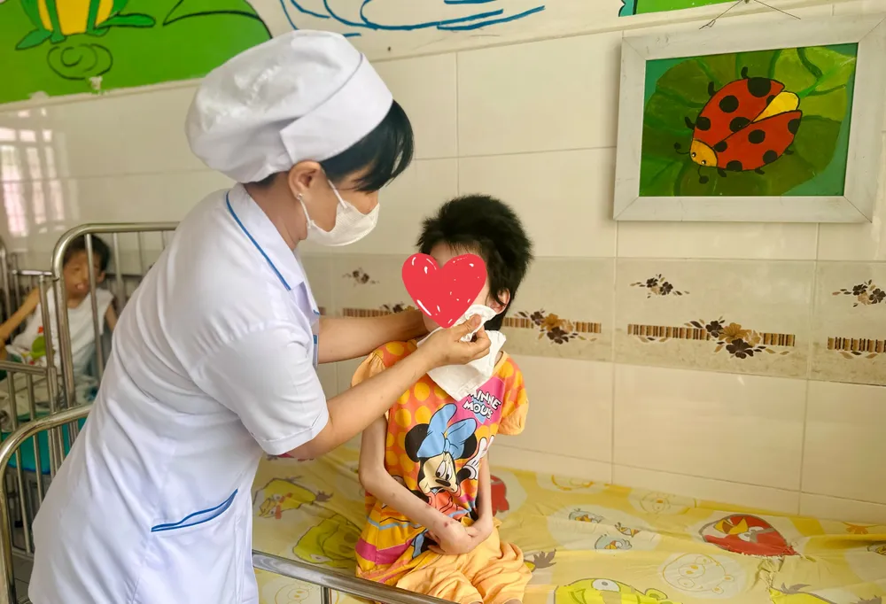 Nhân viên y tế Làng Hòa Bình mỗi ngày đều chăm sóc, vệ sinh cá nhân cho các trẻ. Ảnh: THẢO PHƯƠNG