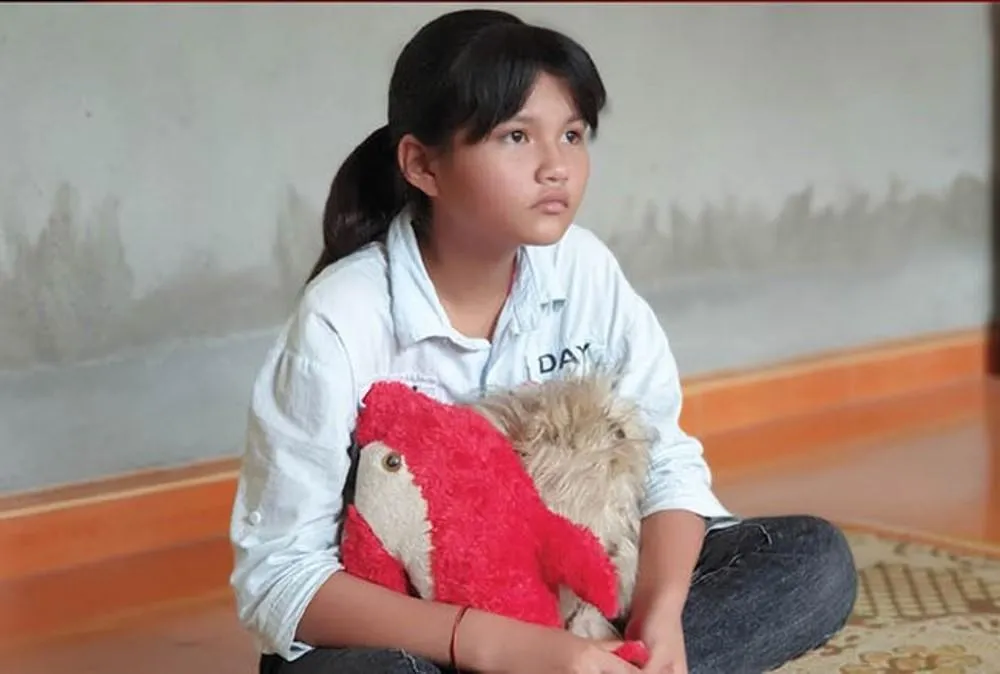 Nguyễn Tường Vy với kỷ vật mẹ để lại. Ảnh trưng bày tại triển lãm.