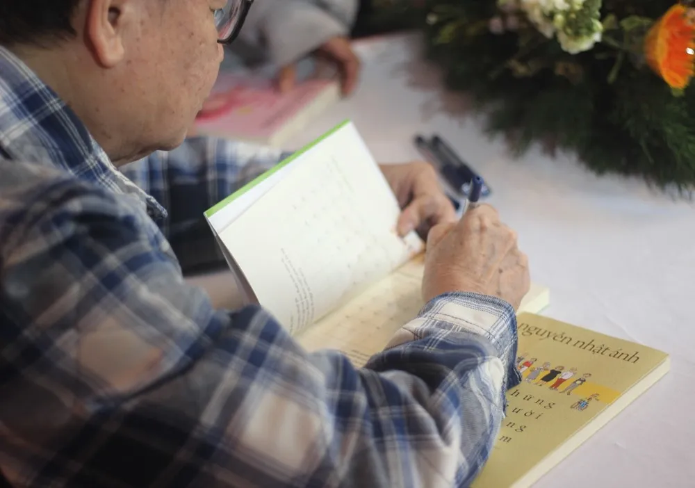 Nhiều bạn đọc cầm theo rất nhiều cuốn sách của nhà văn để xin chữ ký, tuy nhiên ông chỉ ký khoàng hai cuốn sách và có quy định về cả thời gian sách được xuất bản. Ảnh: VT