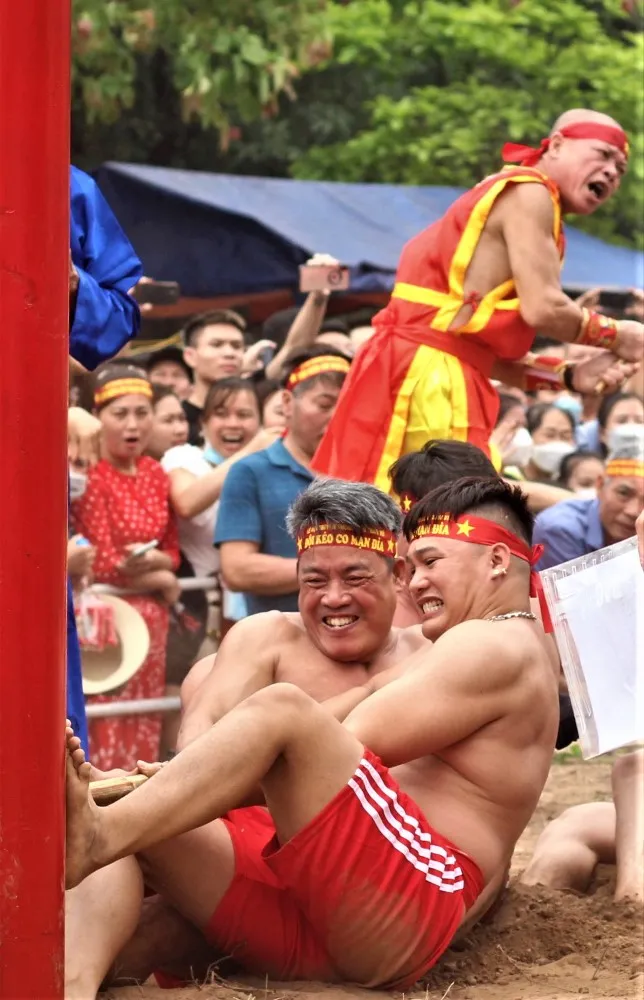 Mỗi đội kéo co từ 15, 17 hoặc 19 người tùy theo từng năm và có một tổing cờ. Trai kéo co cởi trần, mặc quần ngắn, buộc thắt lưng đỏ, đầu chít khăn đỏ in tên từng mạn. Ảnh: VIẾT THỊNH.