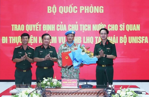 Thượng tướng Hoàng Xuân Chiến trao Quyết định của Chủ tịch nước cho Trung tá Đặng Quốc Tuấn đi thực hiện nhiệm vụ gìn giữ hòa bình Liên hợp quốc. Ảnh: TTXVN.
