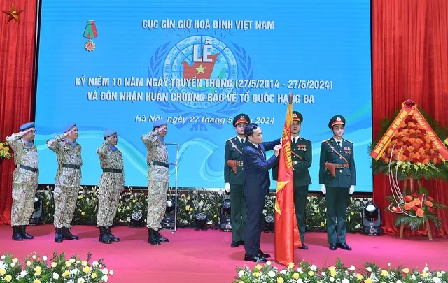 Phó Thủ tướng Trần Lưu Quang gắn Huân chương Bảo vệ Tổ quốc hạng Ba lên cờ truyền thống của Cục Gìn giữ hoà bình Việt Nam Ảnh: VGP Lực lượng Gìn giữ hòa bình Việt Nam