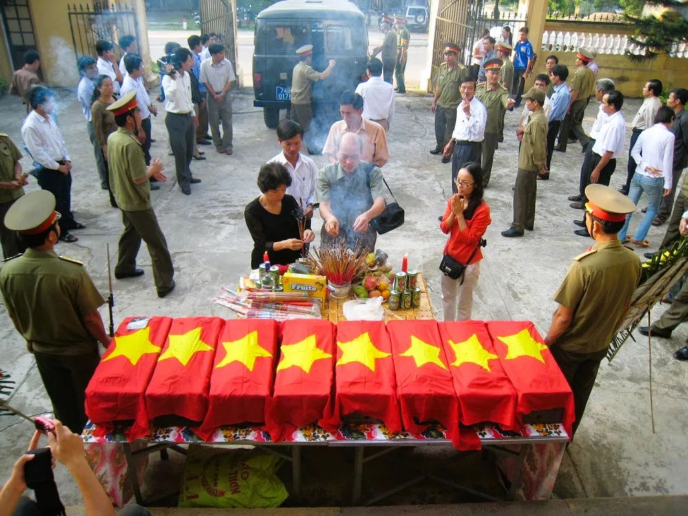 Chị Ngô Thị Thúy Hằng (áo đỏ) bên các hài cốt liệt sĩ vừa được quy tập. Ảnh: NVCC. hang-marin-nguoi-di-tim-than-nhan-cho-liet-si-5.JPG