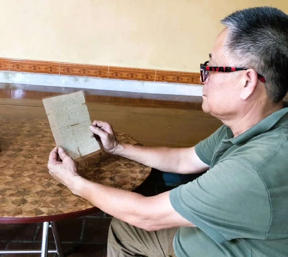 Ông Nguyễn Công Ninh và bức thư bố gửi về từ chiến trường. Ảnh: VT. con liệt sĩ