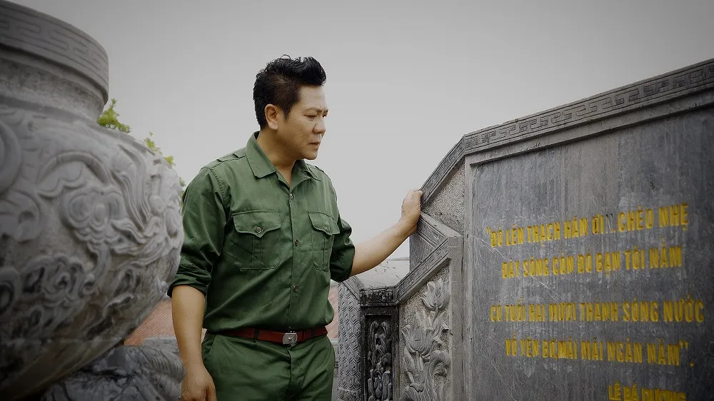 NSND Quốc Hưng bên bia đá có ghi bài thơ của nhà thơ Lê Bá Dương. Thiên hùng ca bất tử