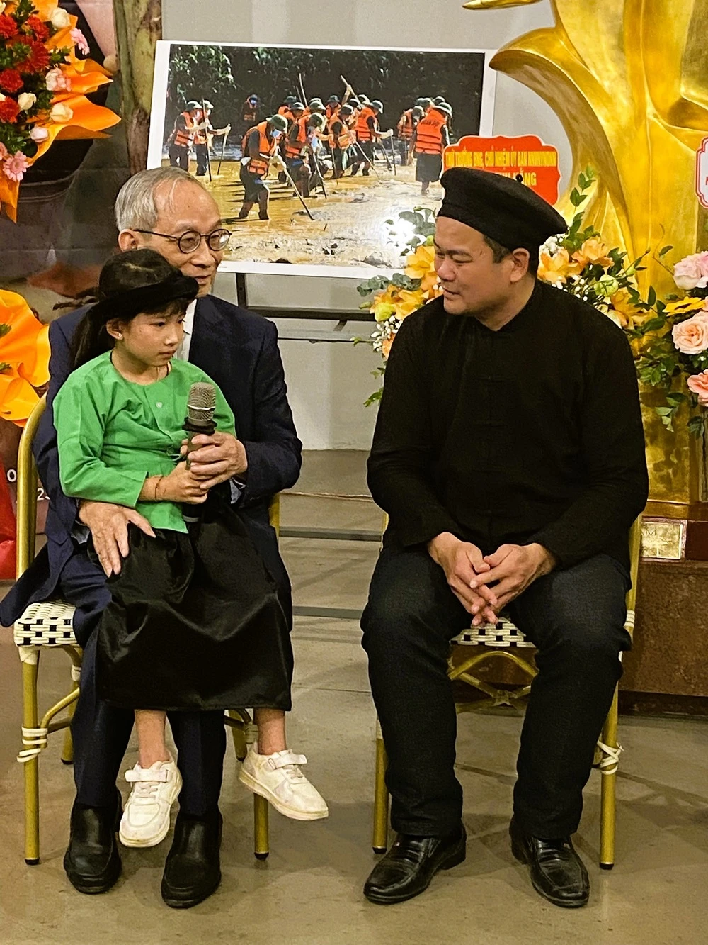'Ông nội' Nguyễn Xuân Khang và một cháu bé ở Làng Nủ mà mình nhận nuôi. Ảnh: VIẾT THỊNH. nguoi-mat-chong-va-2-con-bat-khoc-tai-trien-lam-vuon-len-thon-lang-nu.JPEG