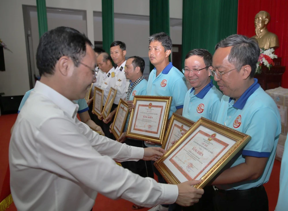Phó Bí thư Thành ủy TP.HCM Nguyễn Văn Hiếu tặng Bằng khen cho các cá nhân, tập thể có thành tích xuất sắc trong chuyến công tác. Ảnh: LONG HỒ
