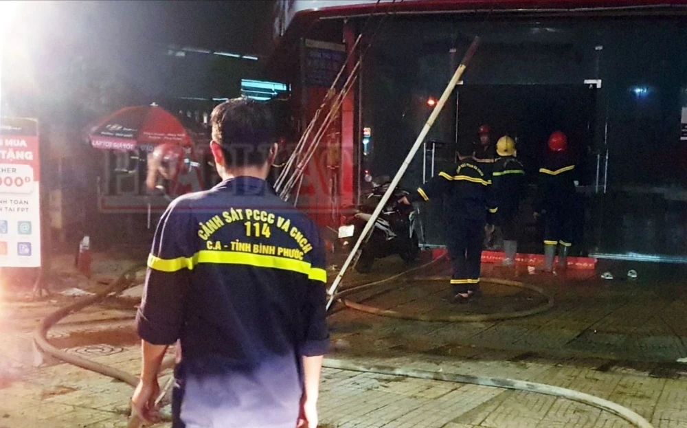Hàng chục cán bộ chiến sĩ nỗ lực dập tắt đám cháy tại cửa hàng. Ảnh: TT cua-hang-fpt-shop-o-binh-phuoc-boc-chay (4).jpg