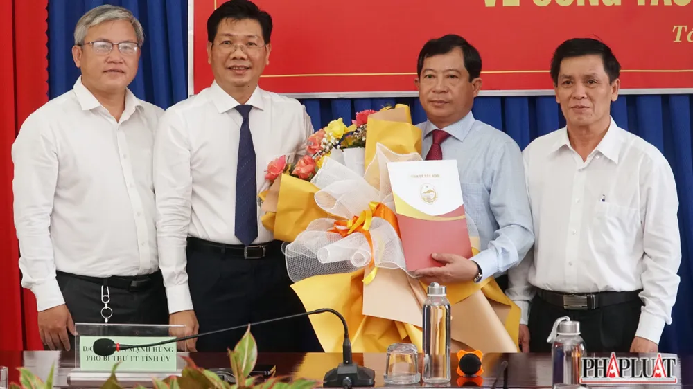 Ông Nguyễn Mạnh Hùng (đeo cà vạt đen) trao Quyết định bổ nhiệm ông Phạm Ngọc Hải (ôm hoa) giữ chức Hiệu Trưởng Trường Chính trị Tây Ninh. Ảnh: VĐ hiệu trưởng trường chính trị Tây Ninh