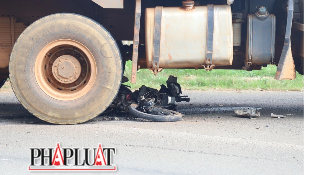 Chiếc xe máy bị cuốn vào gầm. Ảnh: VÕ TÙNG