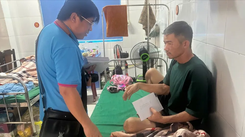 Luật sư Trần Cao Đại Kỳ Quân thăm hỏi, động viên bệnh nhân đang điều trị tại bệnh viện. Ảnh: VY NHUNG Trưởng thôn Kho Vàng được tặng điện thoại
