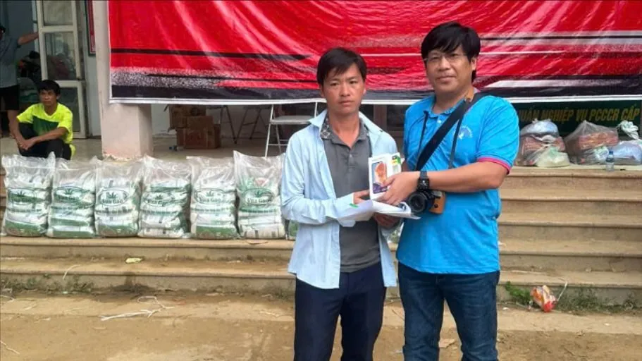 Luật sư Trần Cao Đại Kỳ Quân đã tặng trưởng thôn Kho Vàng một chiếc điện thoại thông minh. Ảnh: VY NHUNG thon-kho-vang.jpg