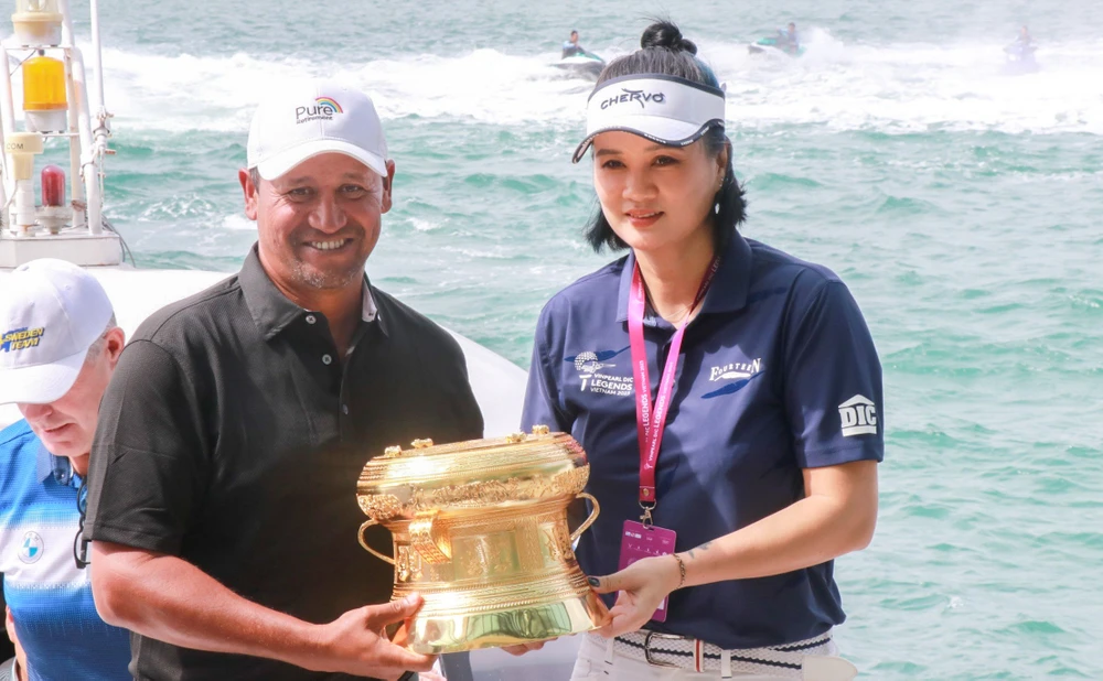 Ông Marius Camber, cố vấn hội đồng quản trị Legends Tour cùng cựu VĐV bóng chuyền Nguyễn Kim Huệ rước cúp vô địch, sáng 27-11