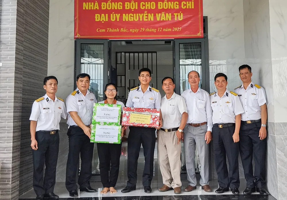 Lãnh đạo Vùng 4 Hải quân trao quà, chúc mừng vợ chồng Đại úy Tú. Ảnh: NN. nhà-23.jpg