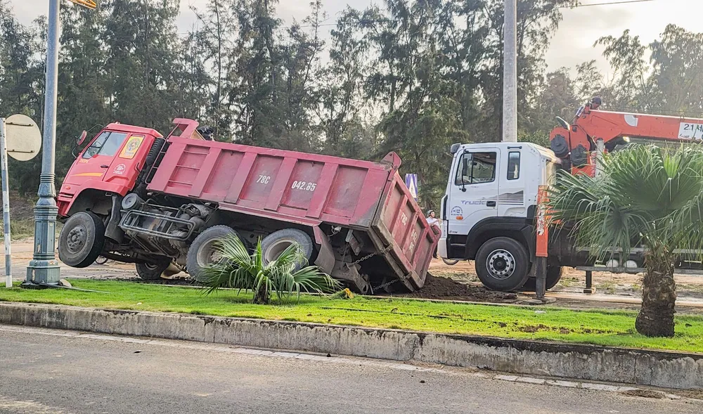 Cơ quan chức năng cẩu xe tải ra khỏi hố, khắc phục sự cố. Ảnh: MINH TOÀN hố tử thần.jpg