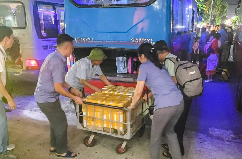 Hành khách đi tàu được trung chuyển bằng ô tô để tiếp tục hành trình. Ảnh: TS H3.jpg