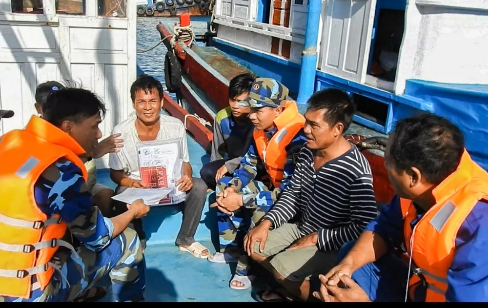 Ngư dân được tặng cờ Tổ quốc, nhu yếu phẩm và tuyên truyền về Chỉ thị 45. Ảnh: DUY TÂN Đẩy mạnh tuyên truyền Chỉ thị 45CT-TTg của Thủ tướng Chính phủ, chung tay khắc phục thẻ vàng của Liên minh Châu Âu.jpg