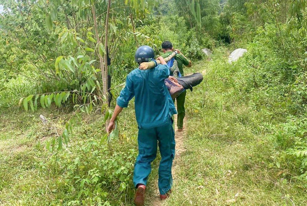 Lực lượng chức năng băng rừng dùng cán võng di chuyển hơn 2 km để đưa người ra ngoài cấp cứu. Ảnh: MT 451873589_122182678154035403_6478784289995095442_n.jpg