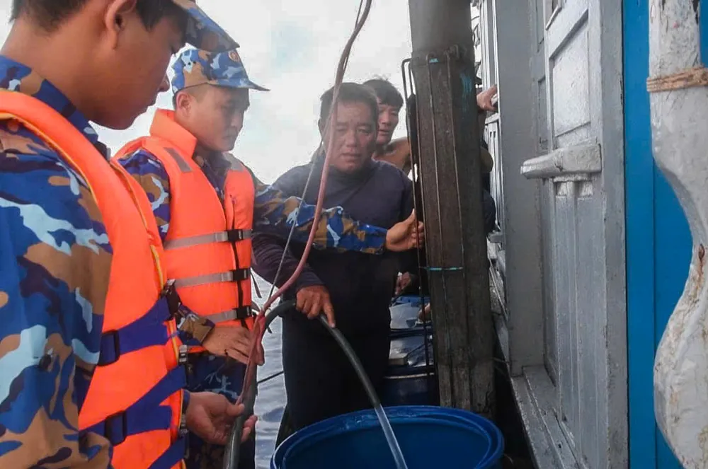 Tiếp tế nước ngọt cho các ngư dân. Ảnh: NGUYỄN NAM Tàu 471 hỗ trợ nước ngọt giúp đỡ ngư dân trên biển.jpg