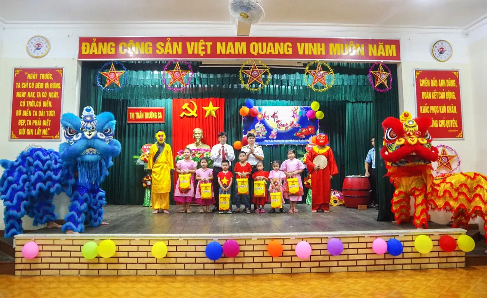 Lãnh đạo, chỉ huy đảo, chính quyền thị trấn Trường Sa tặng quà cho các cháu thiếu nhi. Ảnh: TUYÊN BỐN Lãnh đạo, chỉ huy đảo, chính quyền Thị trấn Trường sa tặng quà cho các cháu thiếu nhi.jpg