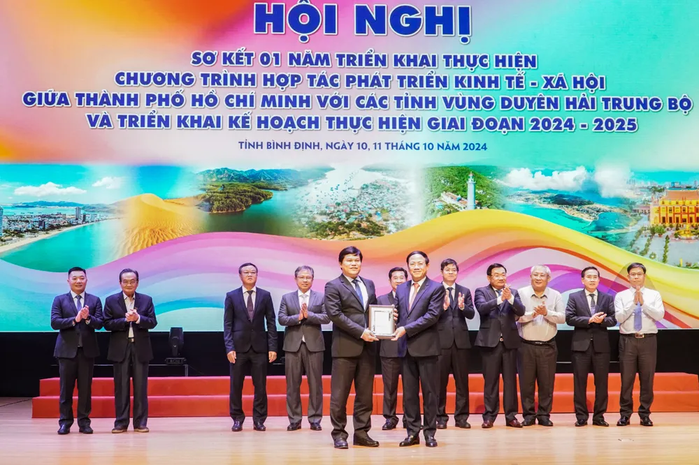 Lãnh đạo tỉnh Bình Định trao cờ đăng cai tổ chức hội nghị tổng kết giai đoạn 2023-2025 cho lãnh đạo UBND tỉnh Quảng Ngãi. Ảnh: HUỲNH HẢI 11.jpg