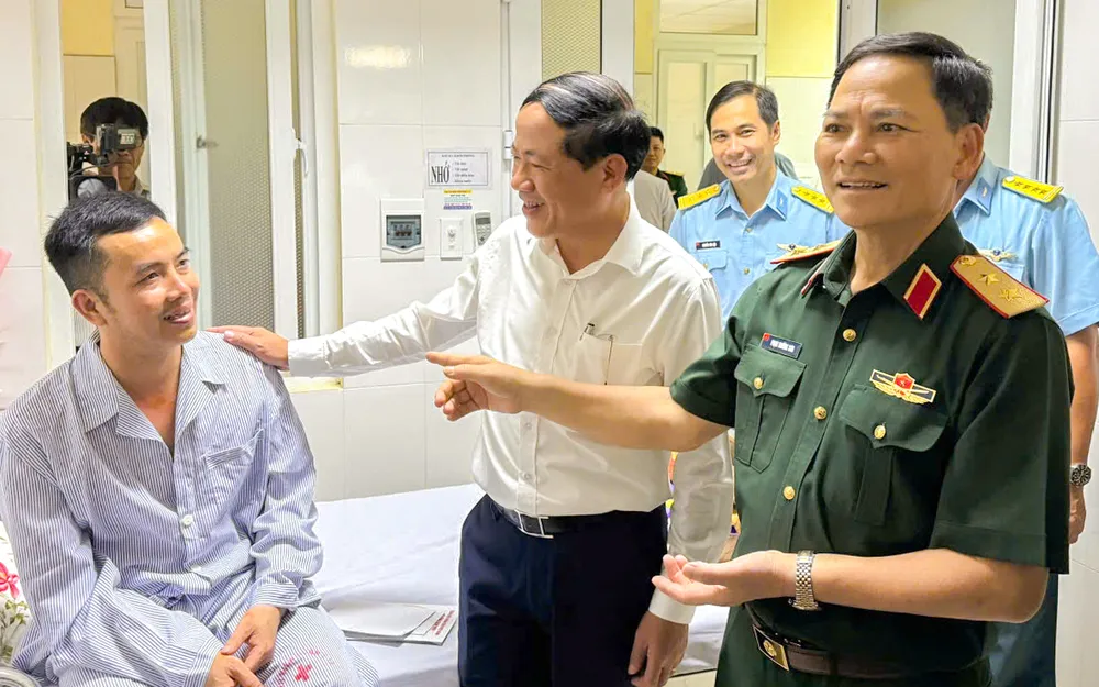 Trung tướng Phạm Trường Sơn và Chủ tịch UBND tỉnh Bình Định Phạm Anh Tuấn thăm hỏi, động viên Thượng tá Nguyễn Hồng Quân. Ảnh: TD thoát khỏi máy bay.jpg