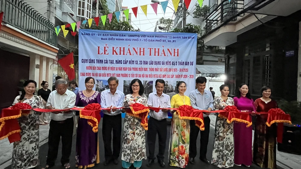 Người dân cùng lãnh đạo Phường 13, Quận Tân Bình cùng cắt băng khánh thành công trình. Người dân và chính quyền