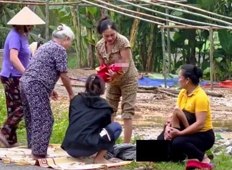 Nhiều người dân đến hỗ trợ sản phụ sinh con bên lề đường. Ảnh: PHAN DŨNG