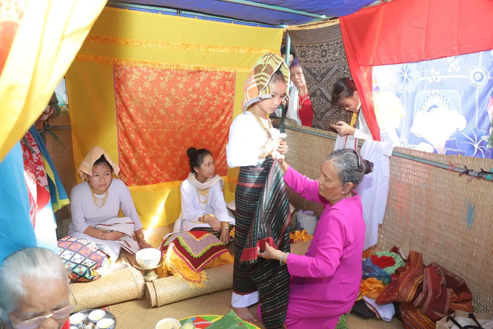 Các thiếu nữ được trang điểm, mặc trang phục truyền thống, búi tóc lên cao trên đỉnh đầu và đeo trang sức… để chuẩn bị cho lễ trưởng thành. 3. Lễ Karơh độc đáo của người Chăm.jpg