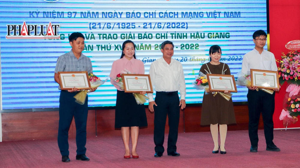 Ông Đồng Văn Thanh (đừng giữa), Chủ tịch UBND tỉnh Hậu Giang trao Bằng khen cho các cá nhân, nhóm tác giả có tác phẩm báo chí xuất sắc tại giải báo chí tỉnh. Ảnh: CHÂU ANH