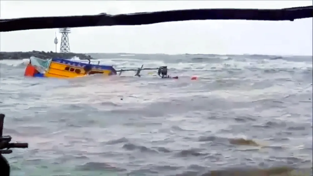 Chiều 12-7, một tàu cá đi từ ngoài biển vào bờ để tránh mưa bão, nhưng khi đến gần bờ thì bị sóng đánh chìm, làm hai cha con mất tích. Ảnh: THY TUẤN