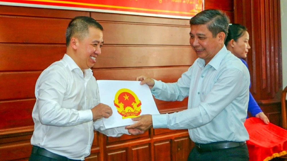 Ông Đồng Văn Thanh (bìa phải), Chủ tịch UBND tỉnh Hậu Giang, trao Quyết định cho ông Lã Hoàng Trung thôi giữ chức Giám đốc Sở TT&amp;TT tỉnh để trở về Bộ. Ảnh: KHƯƠNG DUY