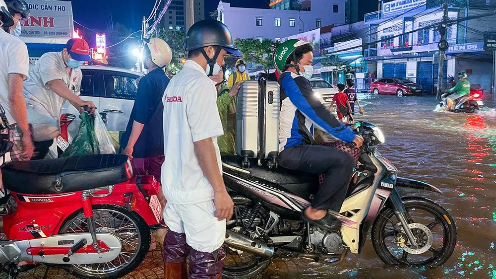 Bên cạnh lực lượng công an, dân quân tự vệ, một số đơn vị kinh doanh xe máy trên địa bàn TP Cần Thơ cũng cử nhân viên đến các điểm ngập hỗ trợ bà con sửa xe miễn phí.