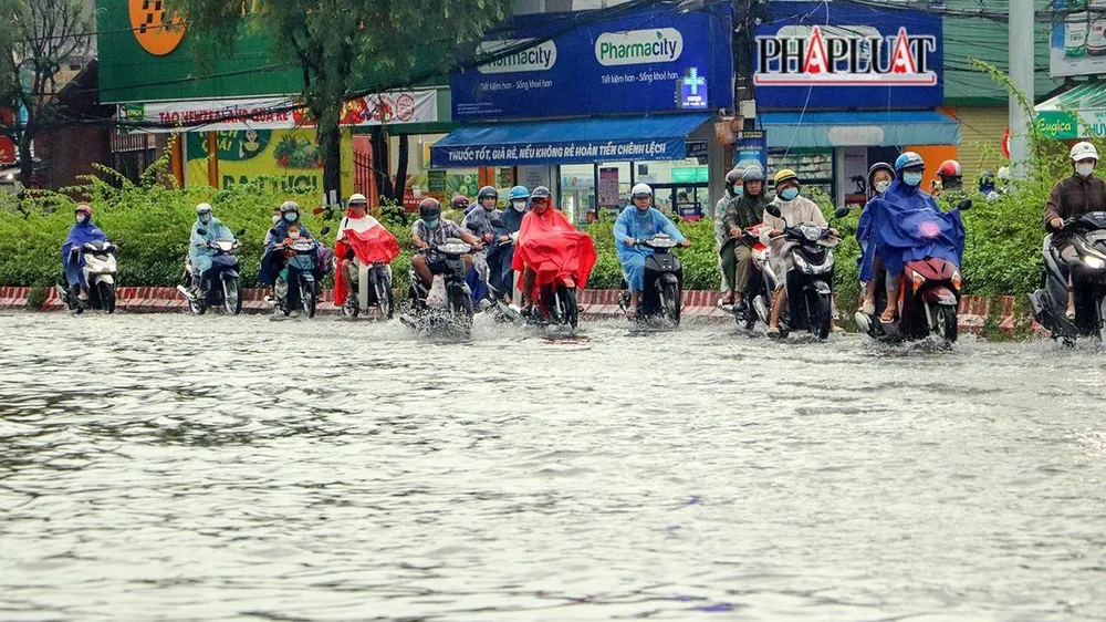Người tham gia giao thông điều khiển phương tiện di chuyển trên làn dành cho xe ô tô để tránh các đoạn ngập.
