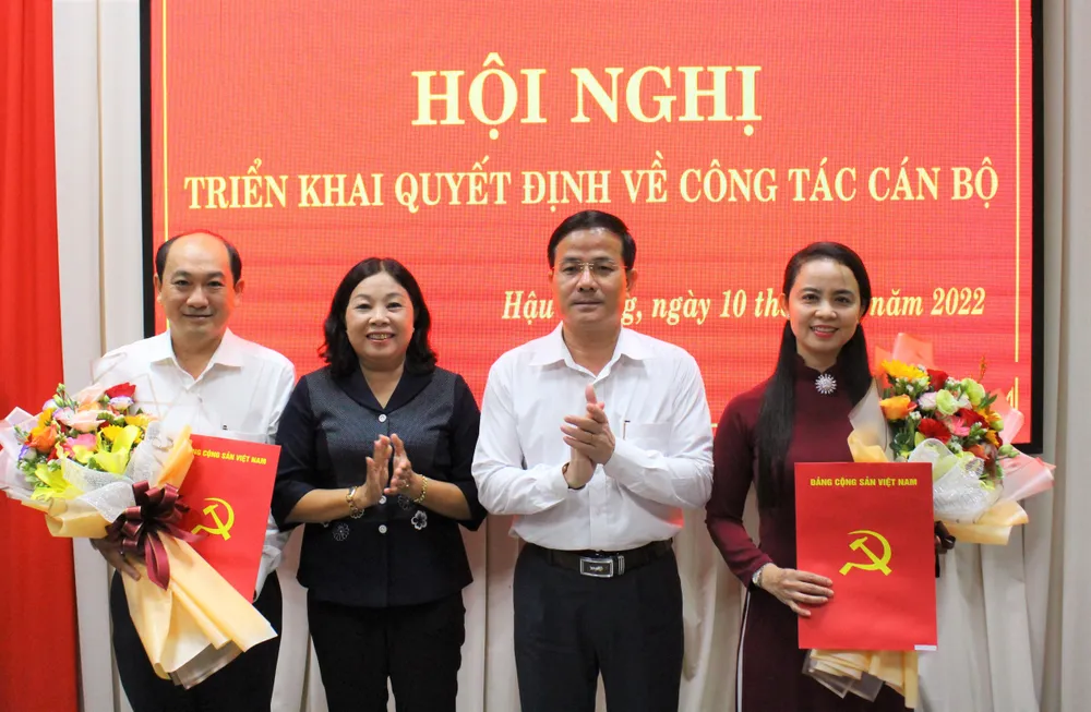 Ông Trần Văn Huyến (thứ hai từ phải qua), Phó Bí thư Thường trực Tỉnh ủy Hậu Giang trao Quyết định và hoa chúc mừng ông Trần Thanh Lâm và bà Võ Thị Mỹ Trang. Ảnh: BT