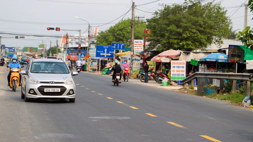 Một số đoạn qua thị trấn, thị tứ trên Quốc lộ 91B đã được đầu tư theo quy mô hai làn xe cơ giới không đáp ứng được nhu cầu vận tải của tuyến đường. Ảnh: CHÂU ANH