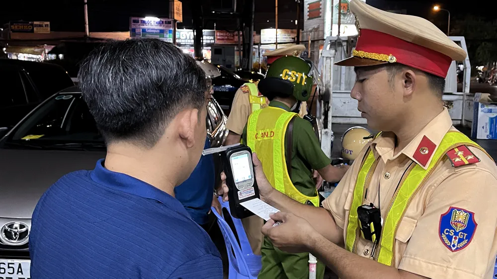 Người đàn ông này có nồng độ cồn trong hơi thở đo được là 0,792 mg/l, trong lúc đoàn tiến hành lập biên bản vi phạm, ông liên tục nghe điện thoại. Ảnh: CHÂU ANH