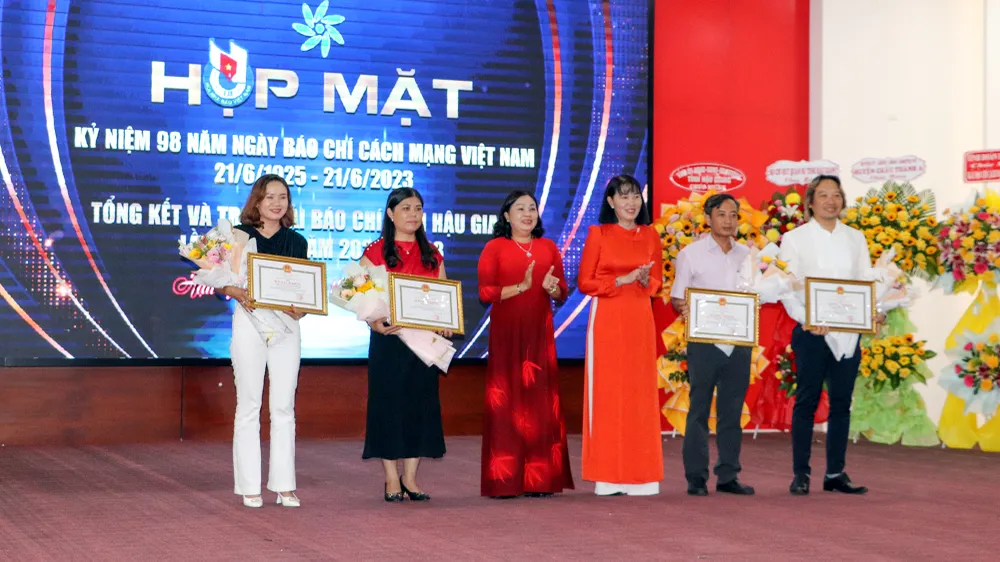 Bà Hồ Thu Ánh (thứ ba từ phải qua), Phó Chủ tịch UBND tỉnh Hậu Giang và bà Mã Thị Tươi (thứ ba từ trái qua), Phó Chủ tịch HĐND tỉnh Hậu Giang trao hoa và bằng khen cho các tác giả, nhóm tác giả đạt giải nhất ở bốn thể loại. Ảnh: CHÂU ANH