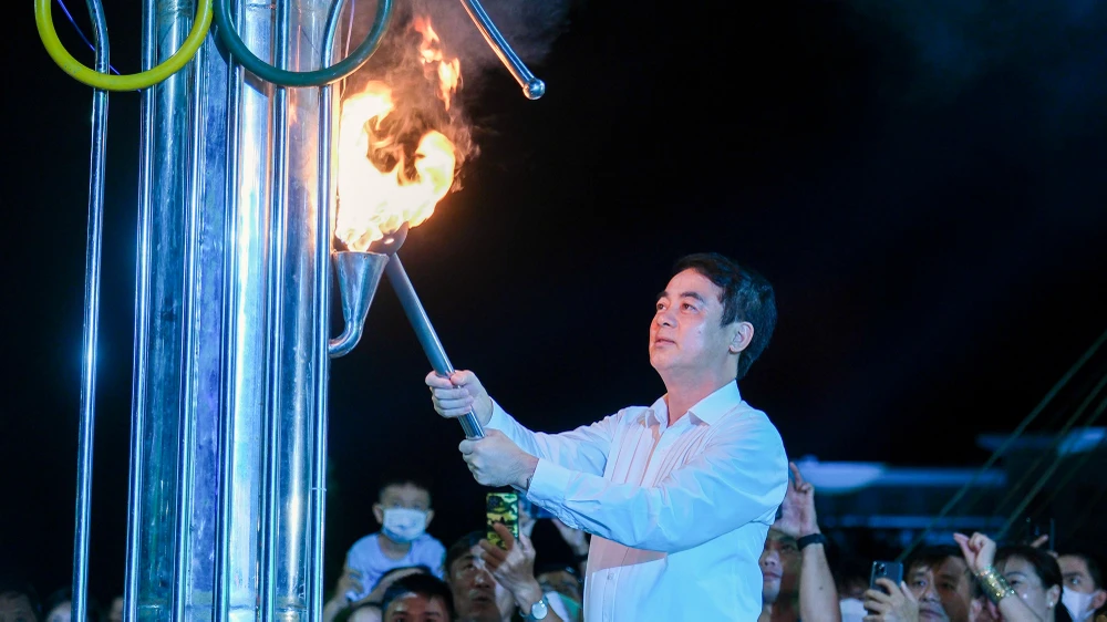 Ông Nghiêm Xuân Thành, Bí thư Tỉnh ủy Hậu Giang thực hiện nghi thức thắp đuốc khai mạc đại hội Thể thao ĐBSCL lần IX và giải Marathon quốc tế Mekong Delta lần thứ IV. Ảnh: TRƯƠNG TIẾN