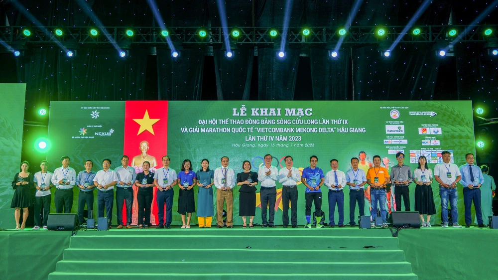 Ông Trần Văn Huyến, Phó Bí thư Thường trực Tỉnh ủy và ông Trương Cảnh Tuyên, Phó Chủ tịch UBND tỉnh Hậu Giang tặng kỷ niệm chương cho 25 nhà tài trợ. Ảnh: TRƯƠNG TIẾN