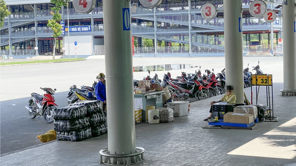Phía ngoài khu vực bán vé có hai người trong trang phục của nhà xe Thành Bưởi cùng nhiều hàng hóa. Ảnh: CHÂU ANH thanh-buoi-3.jpg