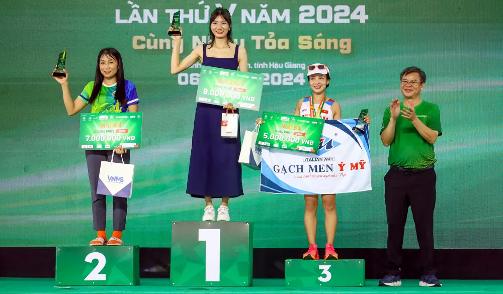 Ông Trương Cảnh Tuyên, Phó Chủ tịch Thường trực UBND tỉnh Hậu Giang trao giải nhất, nhì, ba cho các nữ vận động viên ở cự ly 21km. Ảnh: AP iai-marathon-tinh-hau-giang-7.jpg