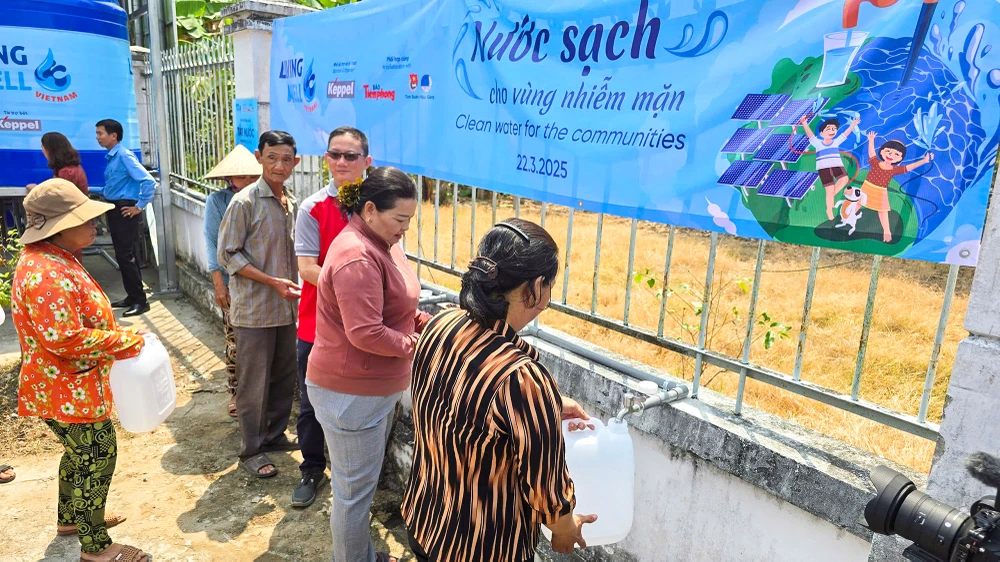 Người dân bày tỏ phấn khởi khi được trao tặng hệ thống máy lọc nước nhiễm mặn dùng năng lượng mặt trời. Ảnh: GIANG LAM Tặng máy lọc nước nhiễm mặn dùng năng lượng mặt trời cho người dân vùng nhiễm mặn tỉnh Hậu Giang