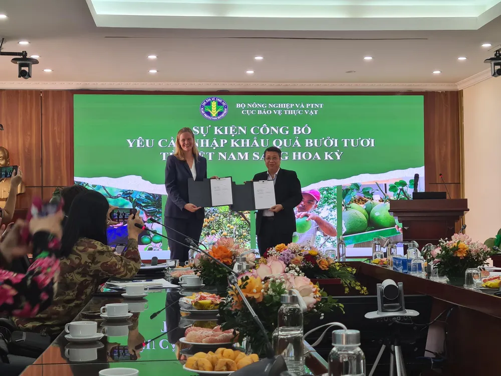 Đại diện phía Mỹ trao văn bản cho Cục Bảo vệ thực vật về các yêu cầu với việc nhập khẩu bưởi tươi từ Việt Nam. Ảnh: LNQ